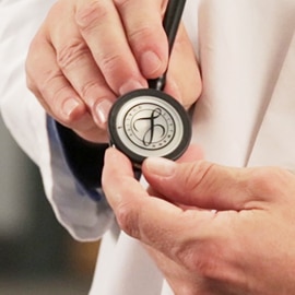 Close up of a doctor holding the chestpiece of a 3M Littmann Stethoscope with the Littmann seal on the diaphragm.